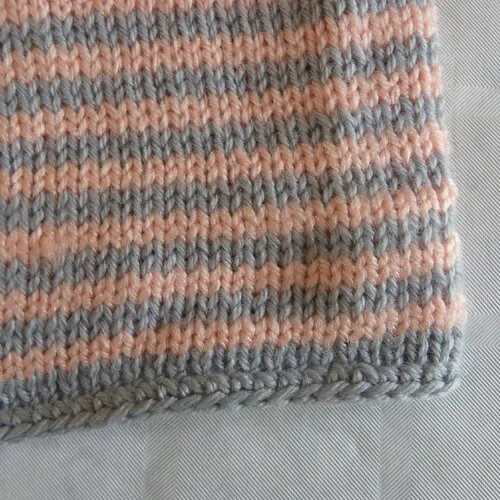 Gilet manches longues à rayures saumons et grises fait mains en laine acrylique pour bébé fille 6 mois